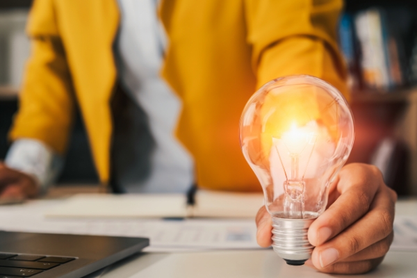 Person holding light bulb that is lit up.